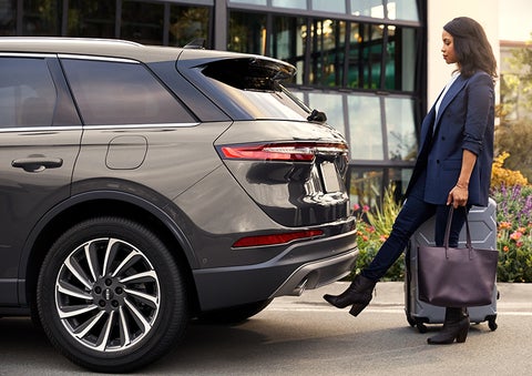A woman with her hands full uses her foot to activate the available hands-free liftgate. | Stivers Lincoln (AL) in Montgomery AL