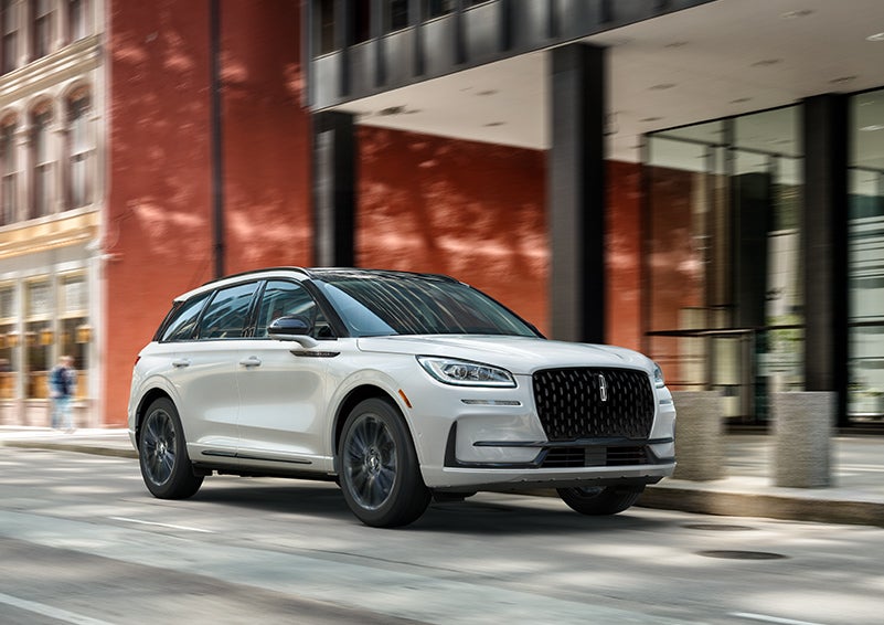 The 2024 Lincoln Corsair® SUV with the Jet Appearance Package and a Pristine White exterior is parked on a city street. | Stivers Lincoln (AL) in Montgomery AL