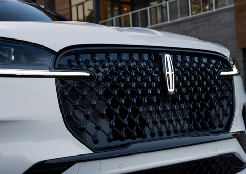 The black grille of a white 2025 Lincoln Aviator® SUV is shown with its fog lights on. | Stivers Lincoln (AL) in Montgomery AL