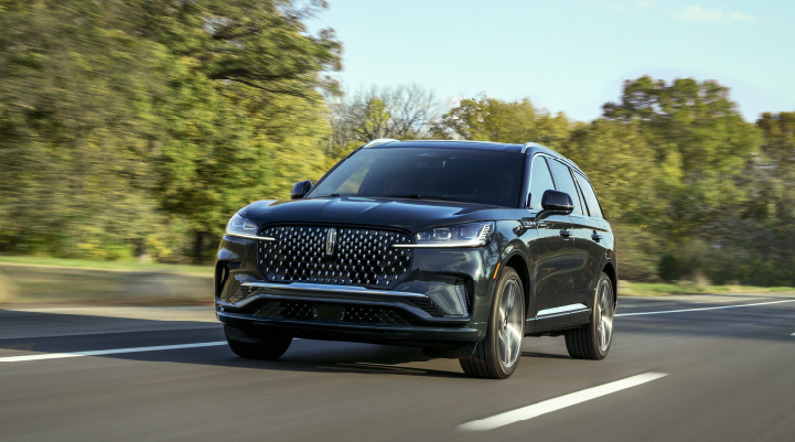 A 2025 Lincoln Black Label Aviator® SUV is being driven down a road lined with trees. | Stivers Lincoln (AL) in Montgomery AL