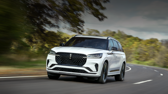 A white 2025 Lincoln Aviator® SUV is being driven down a road lined with trees. | Stivers Lincoln (AL) in Montgomery AL
