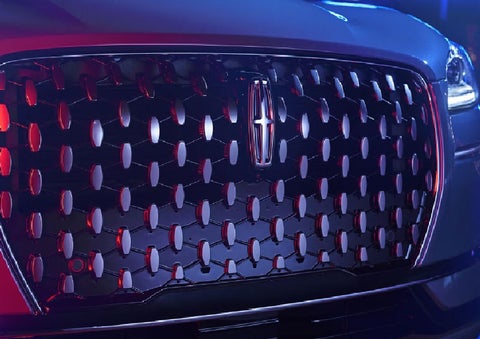 The grille of a 2025 Lincoln Corsair® SUV reflects neon light at night. | Stivers Lincoln (AL) in Montgomery AL