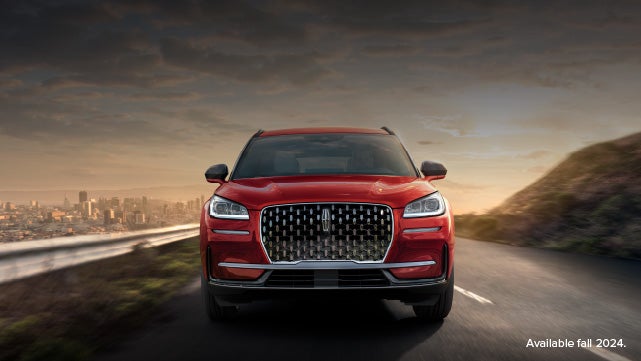 A 2025 red Lincoln Corsair® SUV is being driven down a road at sunset. | Stivers Lincoln (AL) in Montgomery AL
