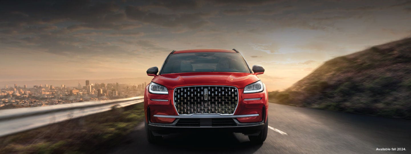 A 2025 red Lincoln Corsair® SUV is being driven down a road at sunset. | Stivers Lincoln (AL) in Montgomery AL