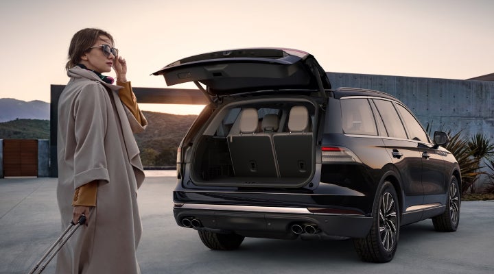 A woman approaches a 2026 Lincoln Aviator® SUV with its rear liftgate open. | Stivers Lincoln (AL) in Montgomery AL