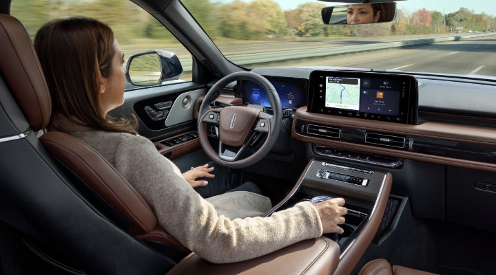 A 2026 Lincoln Aviator® SUV is being driven hands-free on a highway near a forest | Stivers Lincoln (AL) in Montgomery AL