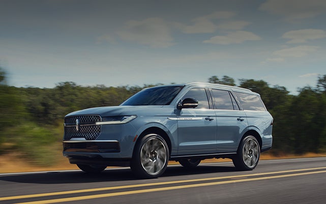 A 2026 Lincoln Navigator® SUV is being driven on a rural highway