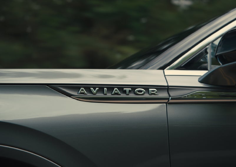 The driver’s side door and fender badging of a gray 2027 Lincoln Aviator® SUV are showcased. | Stivers Lincoln (AL) in Montgomery AL